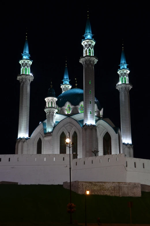 a large white building lit up at night, inspired by Abdullah Gërguri, hurufiyya, black domes and spires, west slav features, cyan, very elegant features