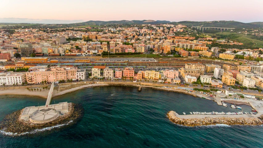 a large body of water next to a city, by Francesco Furini, pexels contest winner, coastline, drone footage, evening light, vincenzo riccardi