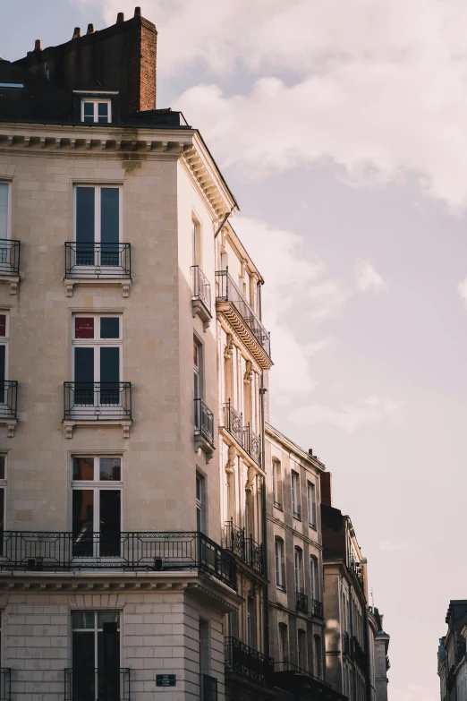 a tall building sitting on the side of a street, by Raphaël Collin, pexels contest winner, neoclassicism, normandy, sunfaded, city apartment cozy calm, delightful surroundings