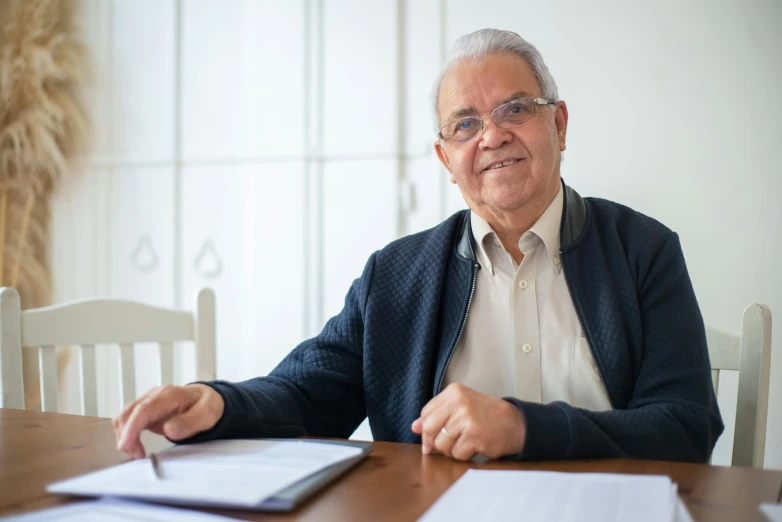 a man sitting at a table in front of a laptop computer, luis nieves sr, portrait image, jovana rikalo, an elderly