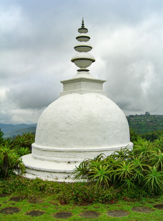 a large white building sitting on top of a lush green field, a statue, sharandula, puṣkaracūḍa, panoramic view, dome