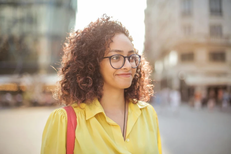 a woman wearing glasses and a yellow shirt, trending on pexels, mixed race, student, slightly sunny, avatar image