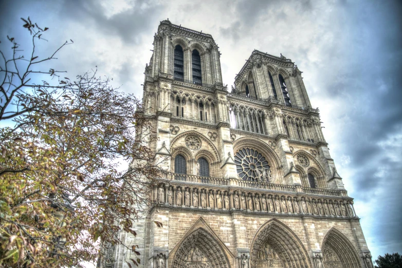 a very tall cathedral with a clock on it's side, a colorized photo, pexels contest winner, square, buttresses, paris, grey