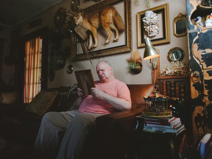 a man sitting on a couch reading a book, a portrait, by Dan Frazier, pexels contest winner, bill dauterive, in an american suburb, gene wolfe, action bronson