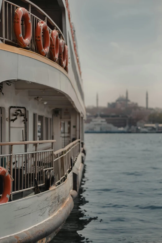 a large boat sitting on top of a body of water, by irakli nadar, close up shot from the side, istanbul, **cinematic, multiple stories