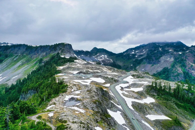 a winding mountain road on a cloudy day, by Doug Wildey, pexels contest winner, renaissance, drone wide shot, mountains of ice cream, seattle, today\'s featured photograph 4k