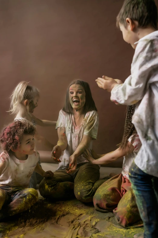 a group of people sitting on top of a bed covered in paint, inspired by Odd Nerdrum, action painting, flour dust flying, happy kid, photo from a promo shoot, a still of a happy