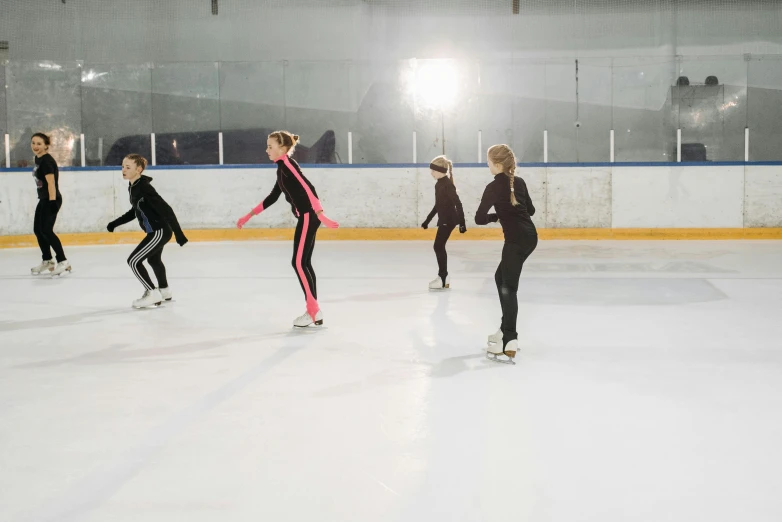 a group of people skating on an ice rink, arabesque, wearing a tracksuit, inner glow, f4.5, aerodynamic