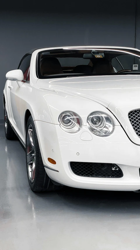 a white bentley car parked in a garage, by Ben Zoeller, superdetail, headlight washer, demur, convertible