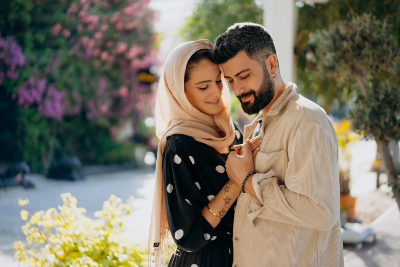 a man and a woman standing next to each other, pexels contest winner, hurufiyya, embracing, arabic, a handsome, square
