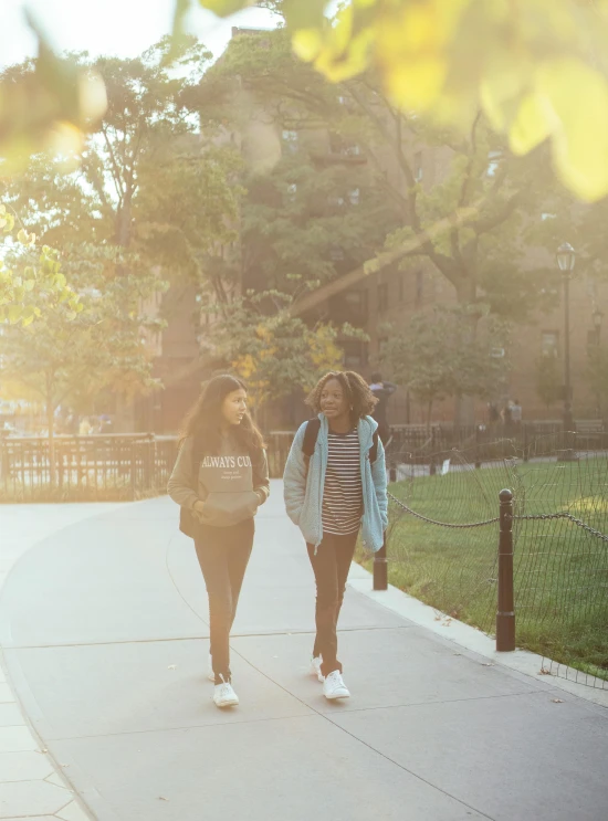 a couple of women walking down a sidewalk, by Washington Allston, trending on unsplash, happening, golden hour 8k, harlem, high school girls, instagram story