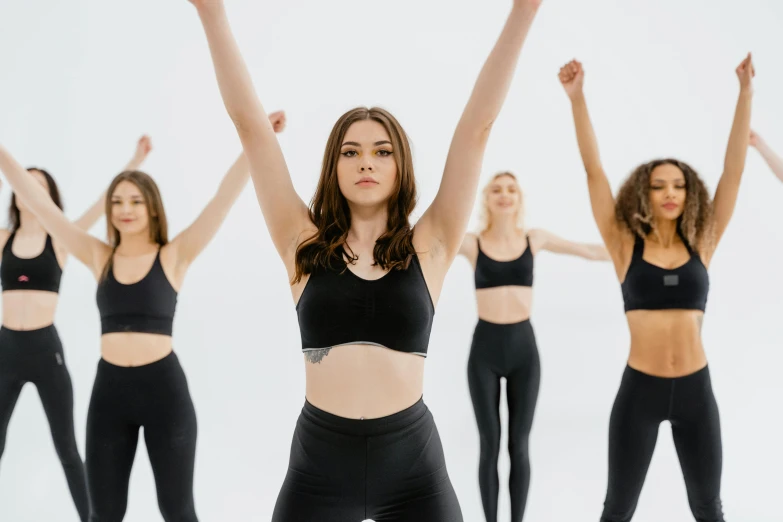 a group of women standing in a line with their arms in the air, trending on pexels, arabesque, she is wearing a black tank top, wearing tight simple clothes, animation, manuka
