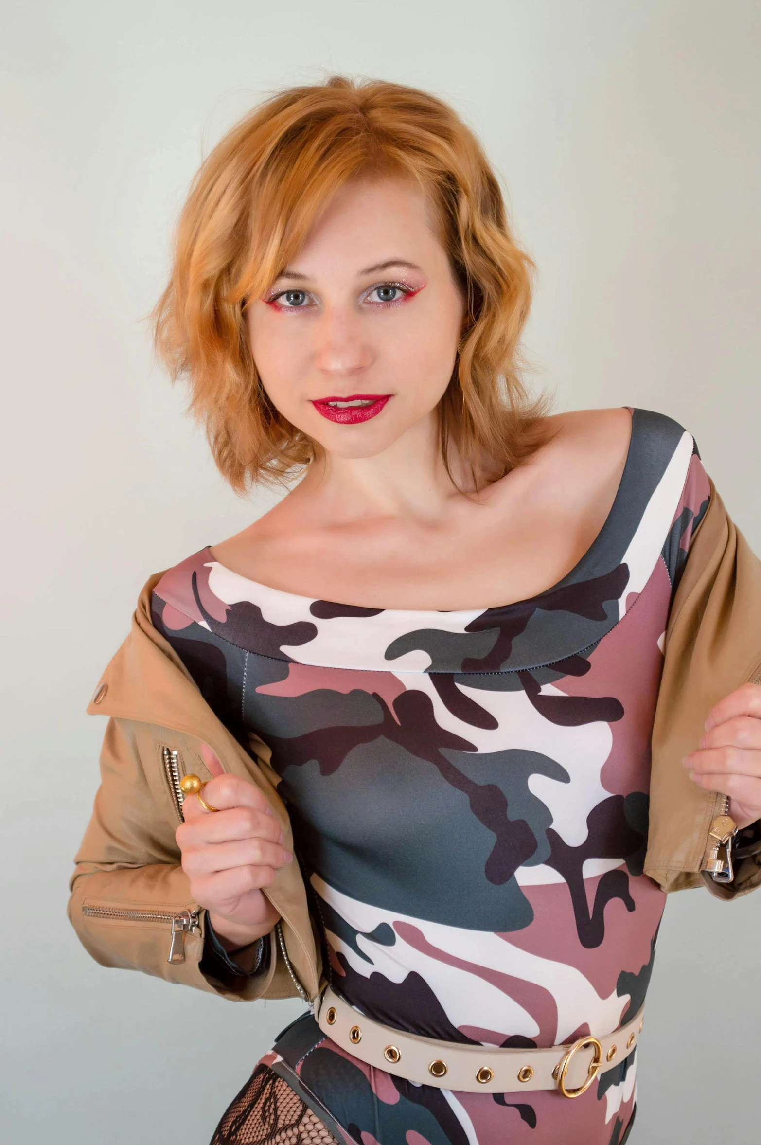 a woman in a camouflage dress poses for a picture, an album cover, inspired by Vasile Hutopila, amouranth, low quality photo, (((rusty))), casual clothing