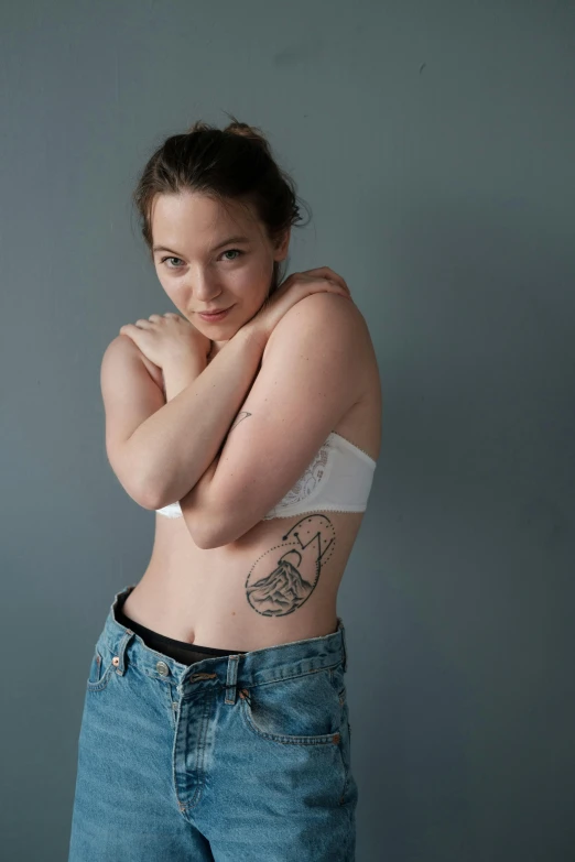 a woman with a tattoo on her stomach, pexels contest winner, portrait sophie mudd, plain background, sydney sweeney, subreddit / r / whale