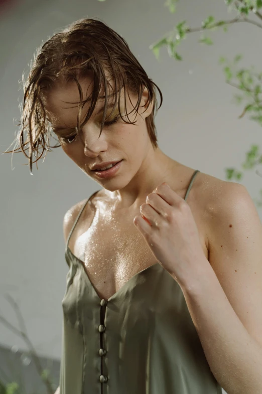 a woman with wet hair wearing a green dress, trending on pexels, wearing a camisole, revealing clothes, skincare, pale skin