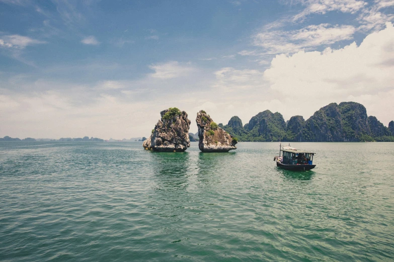 a couple of boats floating on top of a body of water, unsplash contest winner, visual art, vietnam, limestone, vintage photo, high quality image”