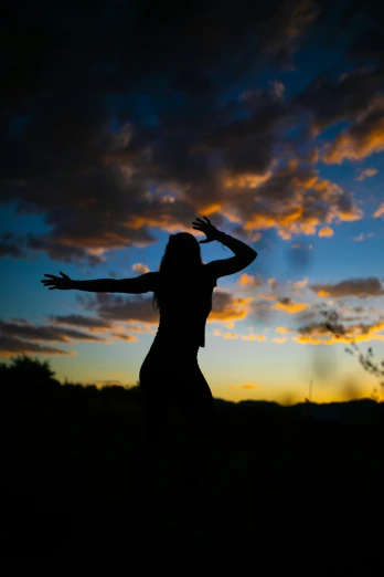 a woman standing on top of a grass covered field, ((sunset)), tribal dance, shot with sony alpha 1 camera, skies