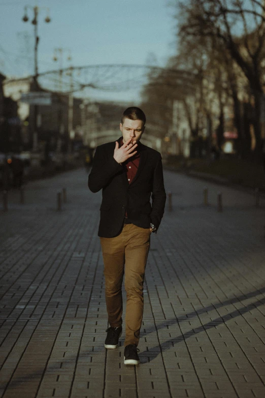 a man walking down a street talking on a cell phone, an album cover, unsplash, well-groomed model, dmitry prozorov style, smoking and bickering, walking at the park