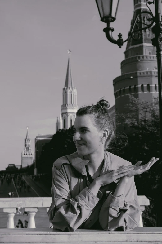 a black and white photo of a woman eating pizza, a black and white photo, inspired by Dmitry Levitzky, unsplash, socialist realism, cathedral in the background, kremlin, posing with crossed arms, red peaks in the background