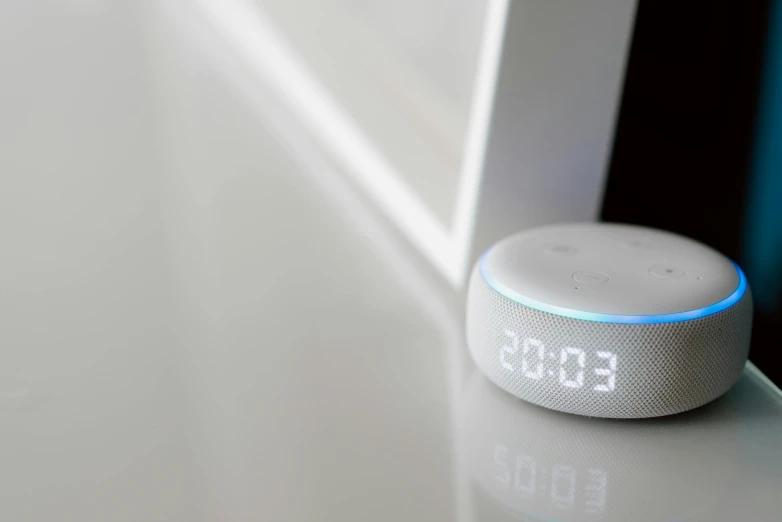 a smart device sitting on top of a table, dials, white, amazon, speech