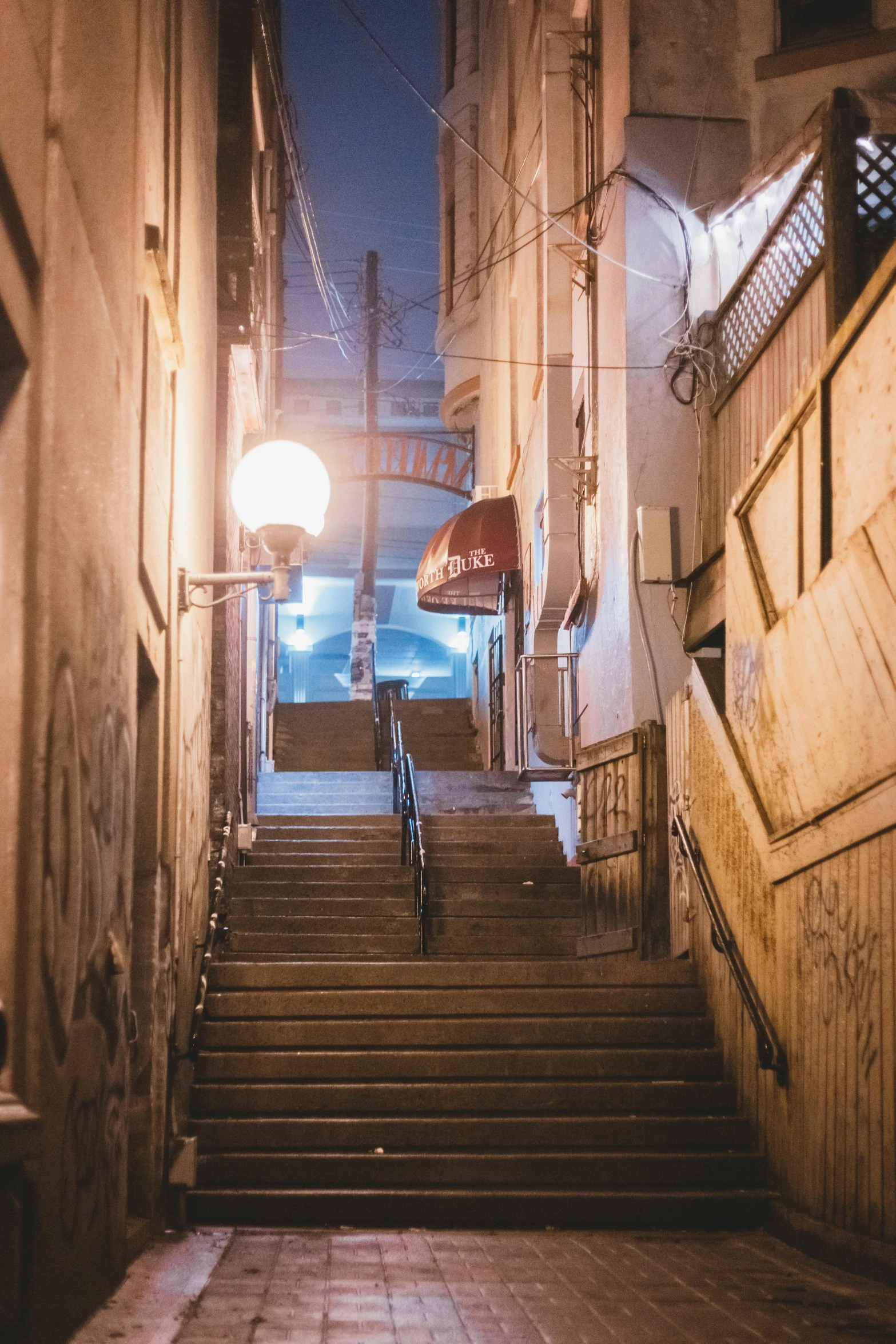 a set of stairs going up the side of a building, inspired by Elsa Bleda, unsplash contest winner, mingei, in a japanese town at night, old jeddah city street, underground city, nightlife