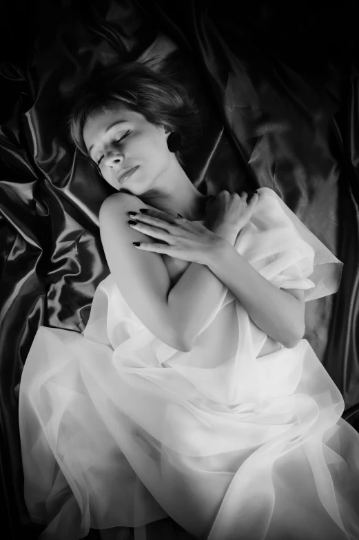 a black and white photo of a woman laying in bed, inspired by George Hurrell, surrealism, soft silk dress, 15081959 21121991 01012000 4k, medium format. soft light, ekaterina