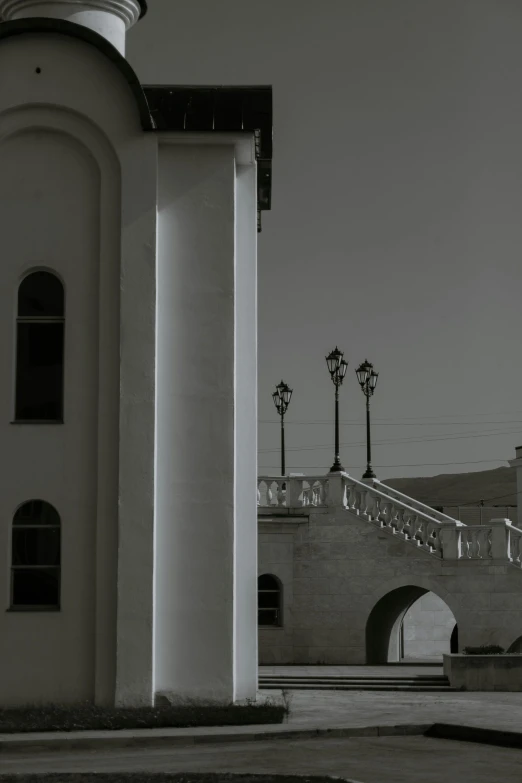 a black and white photo of a clock tower, a black and white photo, inspired by Lajos Gulácsy, baroque, white sweeping arches, street lanterns, color photograph, white pale concrete city