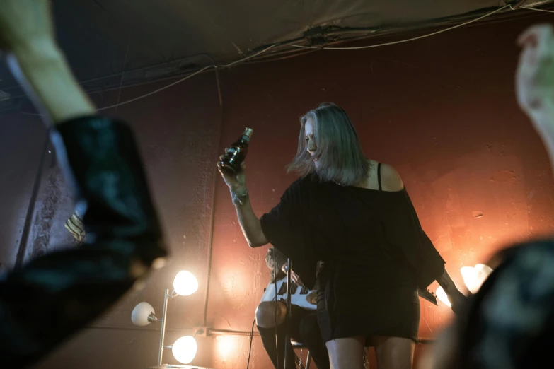 a group of people standing on top of a stage, a portrait, by David Begbie, pexels contest winner, glam rockers drinking wine, as she looks up at the ceiling, kirsi salonen, 15081959 21121991 01012000 4k