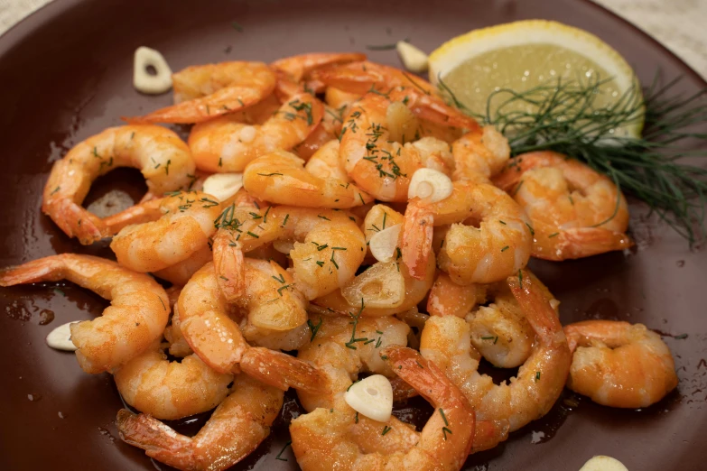 a brown plate topped with shrimp next to a lemon wedge, hurufiyya, 6 pack, in spain, caparisons, medium