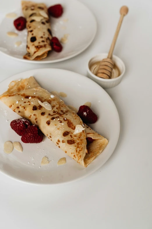 a couple of white plates topped with crepes, unsplash, detailed product image, a blond, kek, 1759