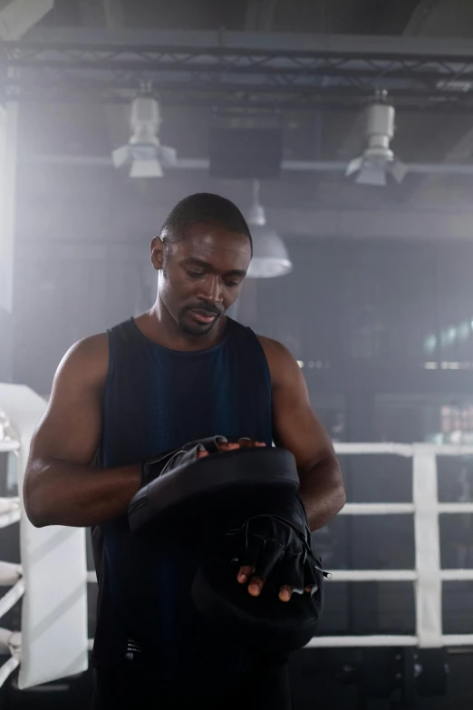 a man holding a boxing glove in a boxing ring, inspired by Samuel Scott, model is wearing techtical vest, mkbhd, full scene shot, hypersphere