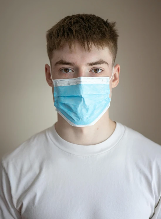 a close up of a person wearing a face mask, by Adam Marczyński, young man with short, medical, blonde guy, blue