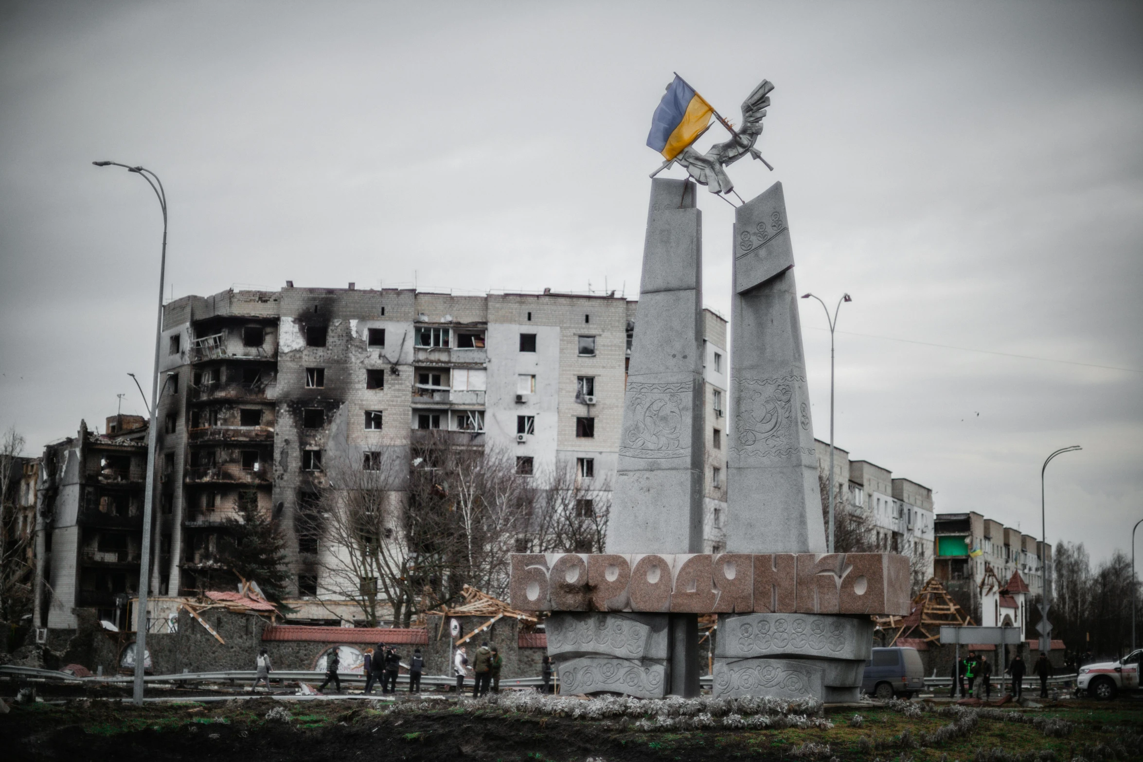 a monument with a flag on top of it, by Boris Vladimirski, pexels contest winner, war in ukraine, concrete housing, square, devastated