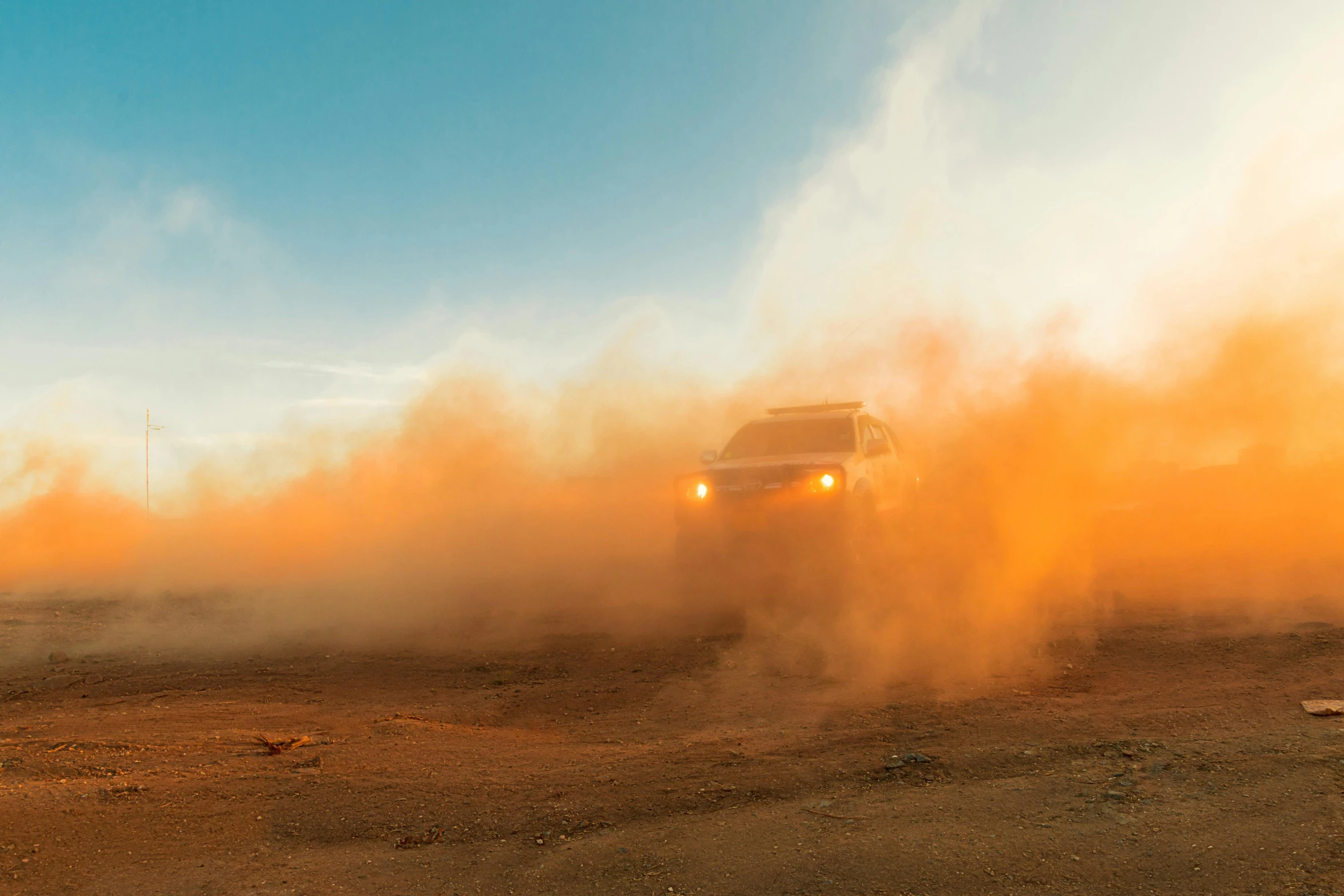 a truck that is driving in the dirt, an album cover, pexels contest winner, auto-destructive art, light orange mist, ultra 4k, instagram post, dust cloud