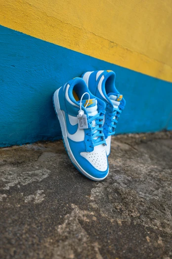 a pair of blue and white sneakers against a yellow and blue wall, unsplash contest winner, graffiti, snacks, dunking, uniform off - white sky, high angle close up shot