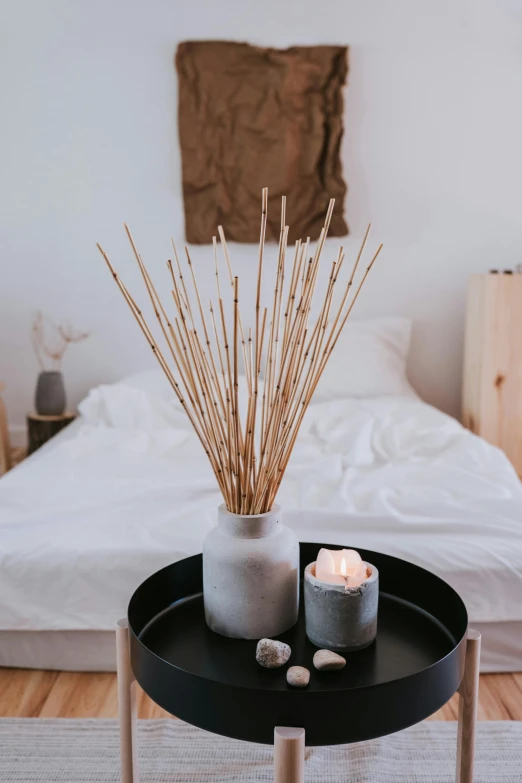 a bed room with a bed a table and two candles, inspired by Li Di, reeds, manuka, forest style studio shot, bouquet