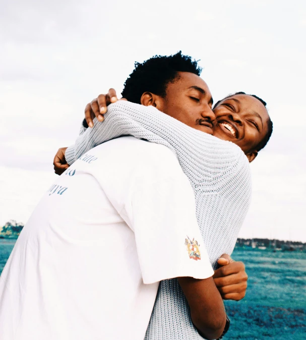 a couple of people that are hugging each other, unsplash, visual art, mkbhd, analog photo, blushing, afar