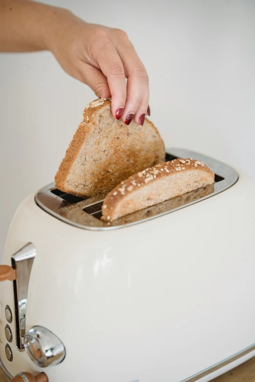 a person putting a slice of bread in a toaster, a portrait, trending on pexels, minimalism, light scatter, amanda lilleston, made of glazed, large tall