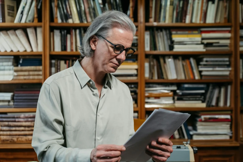 a man that is standing in front of a typewriter, an album cover, pexels, dark grey haired man, reading in library, wim wenders, no - text no - logo