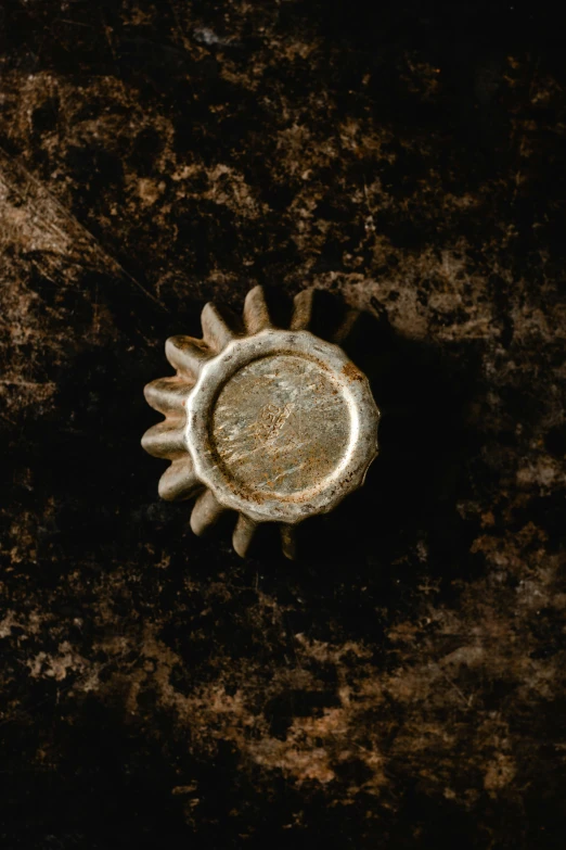 a close up of a metal object on a surface, inspired by Sun Kehong, trending on unsplash, renaissance, flour dust, album cover, weathered, 15081959 21121991 01012000 4k