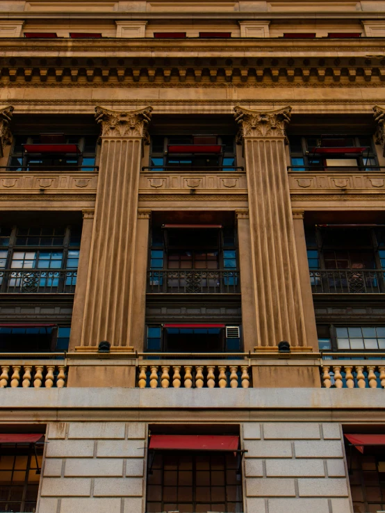 a tall building with a clock on top of it, inspired by Sydney Prior Hall, neoclassicism, red blue and gold color scheme, shot with sony alpha, adorned pillars, yellow windows and details