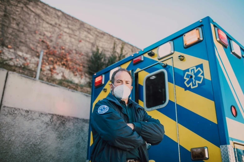 a man wearing a face mask standing in front of an ambulance, pexels, renaissance, fan favorite, avatar image, navy, shot on sony a 7 iii