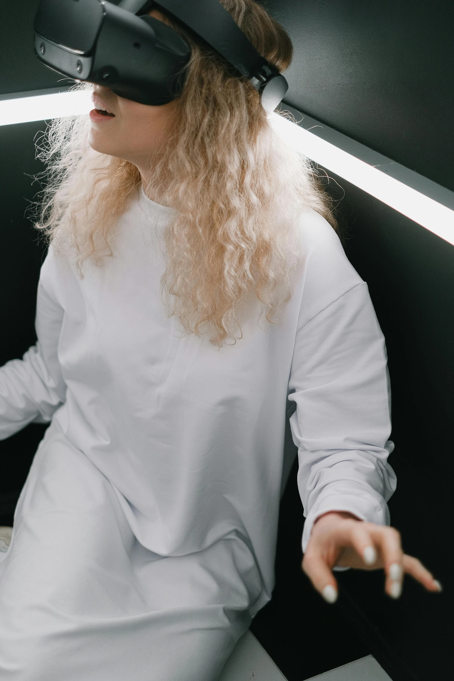 a woman in a white dress wearing a virtual reality headset, inspired by Elsa Bleda, trending on pexels, happening, curly blonde hair | d & d, wearing sweatshirt, an all white human, thicc