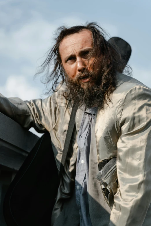 a man with long hair holding a suitcase, inspired by James Baynes, trending on reddit, rick grimes, ( ( theatrical ) ), slide show, his hair is messy and wild