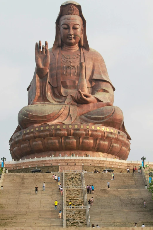 a large statue of buddha sitting on top of a hill, from the front, exterior, sits on a finger, from china