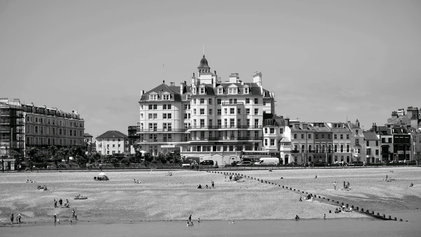 a large building sitting on top of a sandy beach, a black and white photo, pexels contest winner, art nouveau, victorian england style, hotel, wes anderson style, oceanside