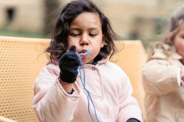 two little girls sitting on a bench brushing their teeth, a child's drawing, by Emma Andijewska, pexels contest winner, holding a blue lightsaber, earbuds, blue gloves, closeup photograph