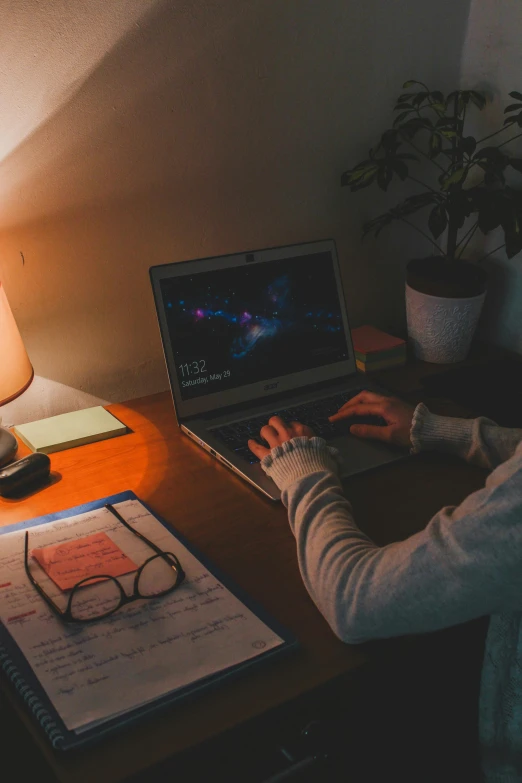 a woman sitting at a desk using a laptop computer, inspired by Elsa Bleda, pexels, night time footage, dark university aesthetic, home setting, high angle shot