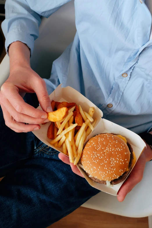 a man sitting on a chair eating a hamburger and fries, pexels, renaissance, square, 6 pack, gold, organic