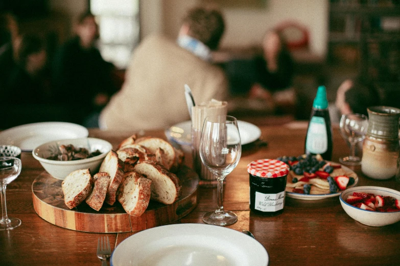 a wooden table topped with plates of food and wine glasses, private press, bread, lachlan bailey, local foods, profile image